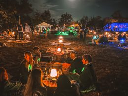 People on a night picnic with lights and drinks at Limbo Festival in Tuscany, Italy