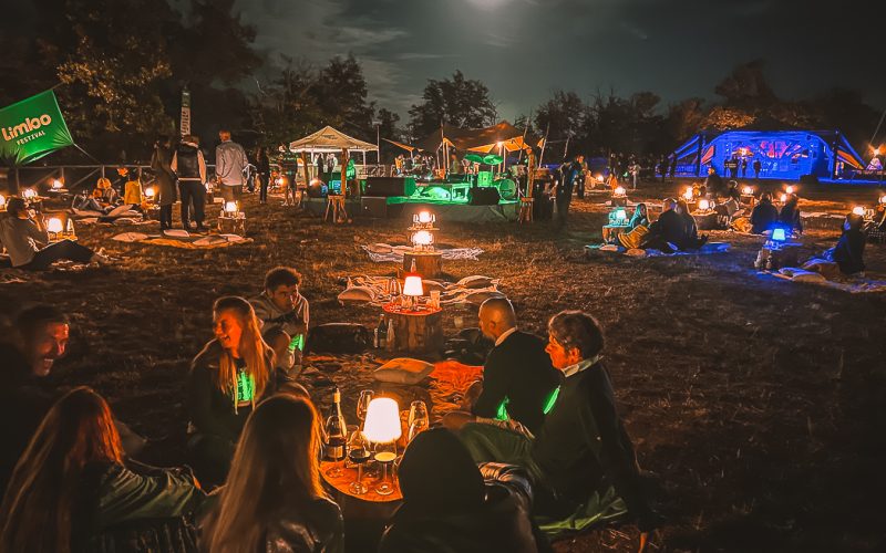 People on a night picnic with lights and drinks at Limbo Festival in Tuscany, Italy