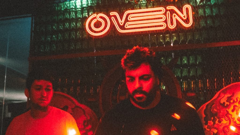 DJs playing under red neon light in the nightclub Oven Club Centro, in Valencia Spain