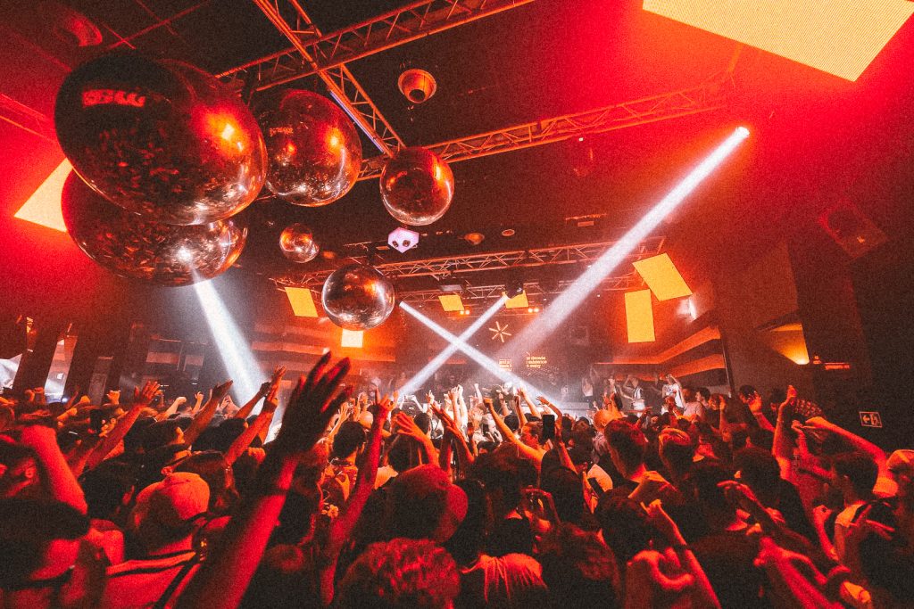 People dancing under red strobe light in the nightclub Spook, in Valencia Spain