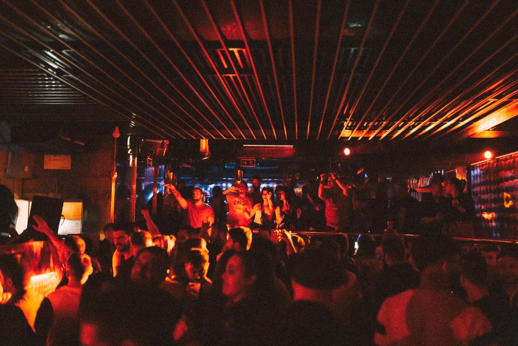 People dancing under red strobe light in the nightclub Miniclub, in Valencia Spain