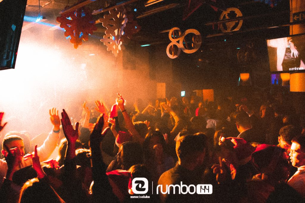 People dancing under orange strobe light in the nightclub Rumbo 144, in Valencia Spain