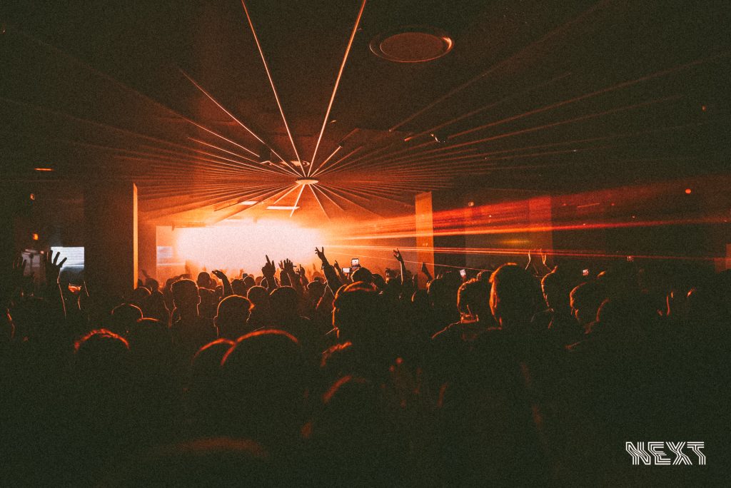 People dancing under orangestrobe light in the nightclub Next, in Valencia Spain