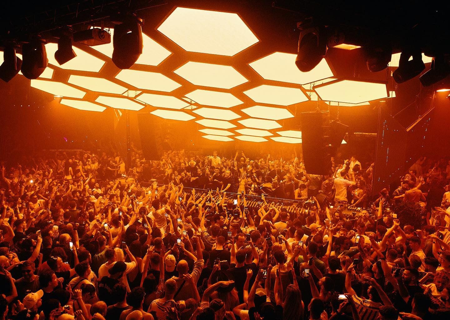 Hexagonal orange lights and crowd dancing at the nightclub Pacha in Ibiza, Spain