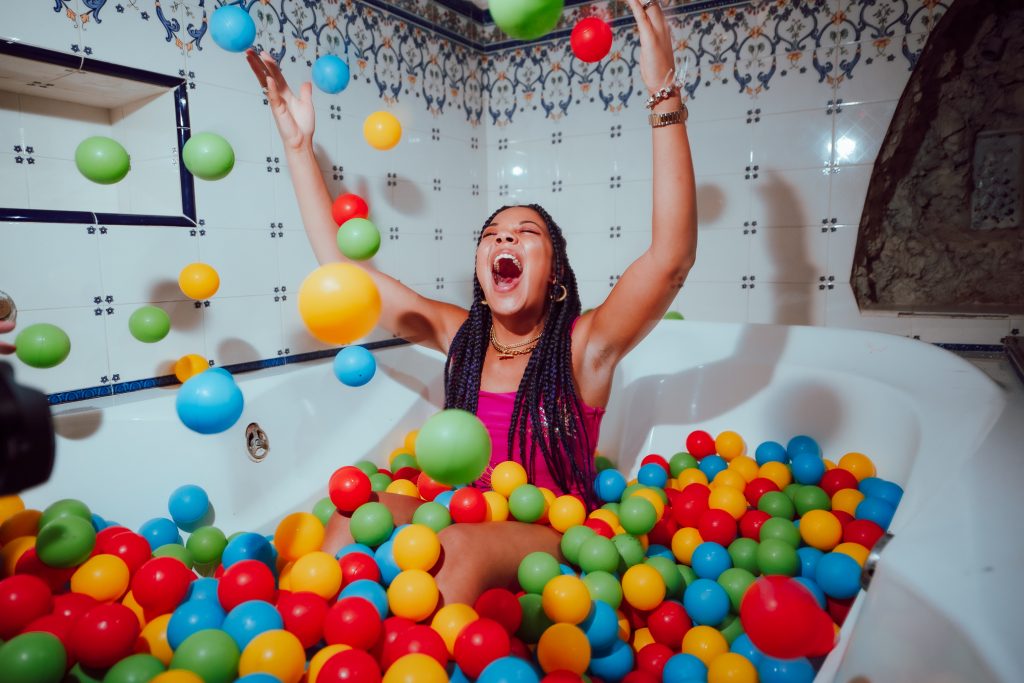 London DJ Jaguar on a bathtub full of colourfull balls in Pikes Ibiza
