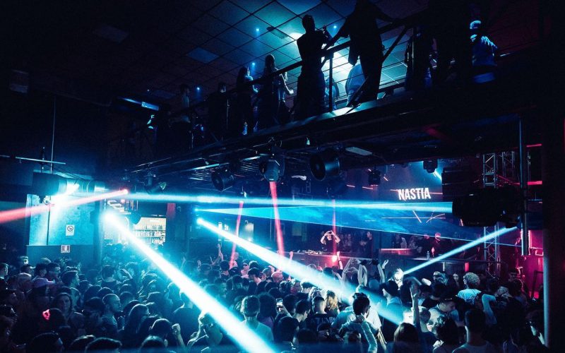 Crowd dancing in nightclub under strobe lights and lasers in Audiodrome, Turin