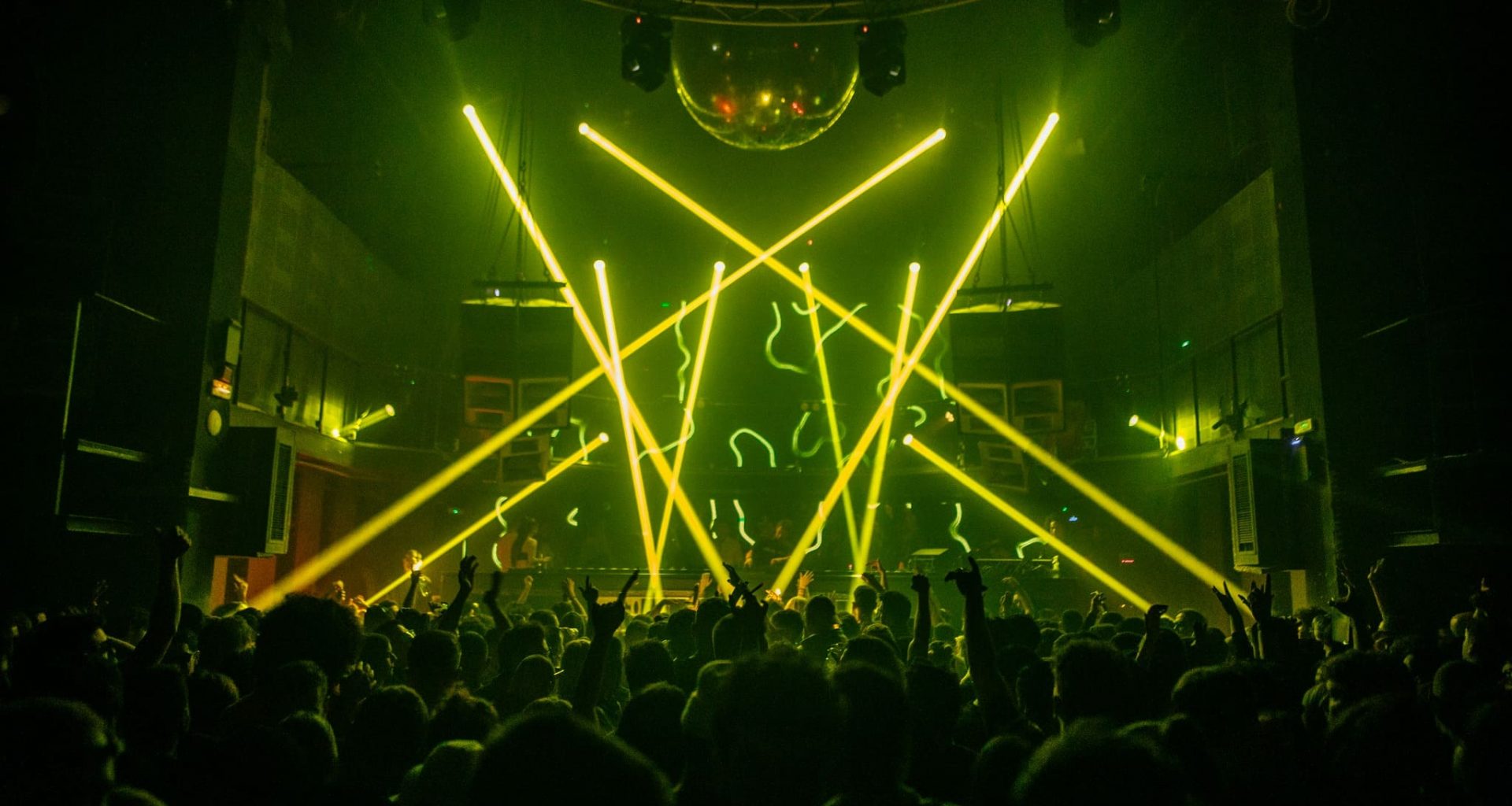 lasers y gente bailando en un club techno en barcelona