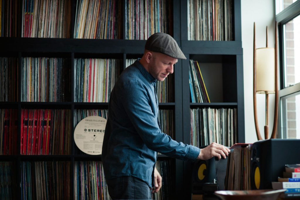 a man standing in front of some vinyls interview dvs1