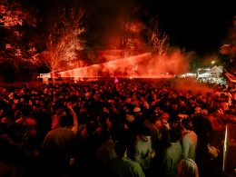 A vibrant night at Días de Campo, with a packed crowd dancing under vibrant red lights in the middle of nature.