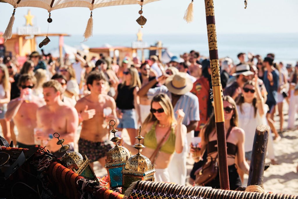 Crowd dancing at a music festival during sunset