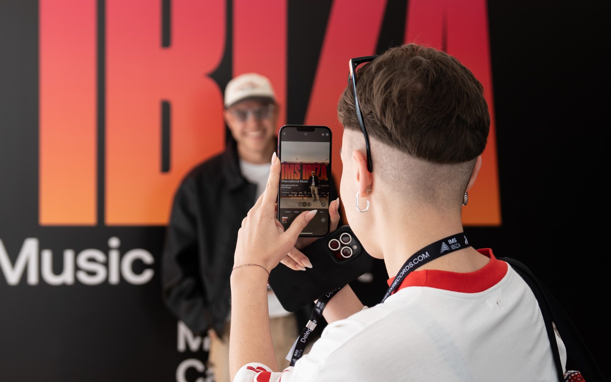girl taking picture with iphone at IMS Ibiza during presentation of IMS Business Report 2025