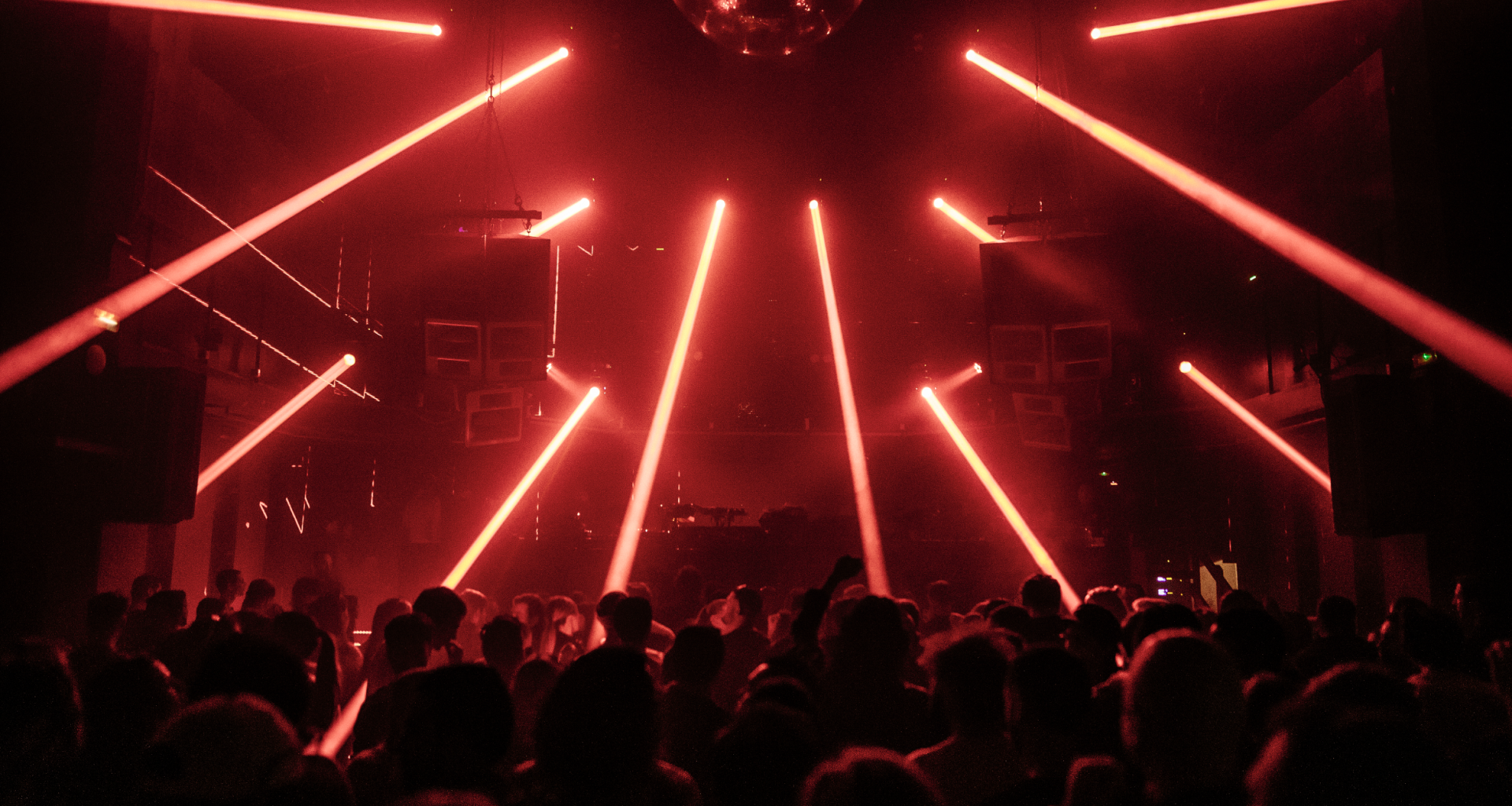 Crowd dancing under red laser lights at INPUT Barcelona 2025 underground club night