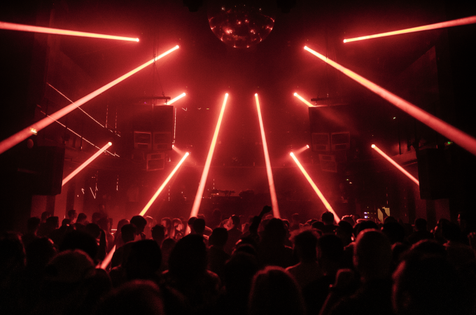 Crowd dancing under red laser lights at INPUT Barcelona 2025 underground club night