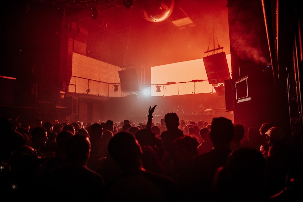 Crowd dancing at INPUT Barcelona 2025 with DJ performing under immersive light visuals