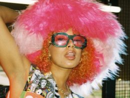 Eliza Rose posing with coloured sunglasses and a big pink furry hat