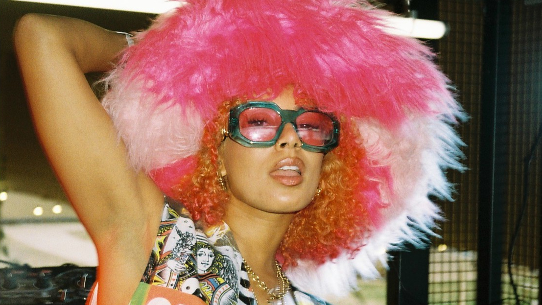 Eliza Rose posing with coloured sunglasses and a big pink furry hat