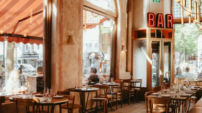 Interior of Café Gitane with large windows, wooden floors, and a warm, Mediterranean feel.