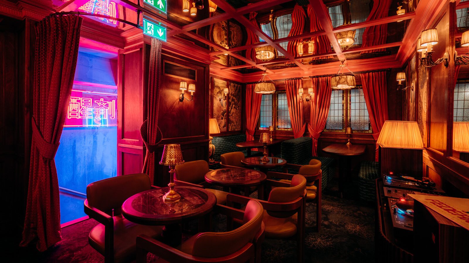 Interior view of the dimly neon-lit, red-toned speakeasy bar for Moyo restaurant.