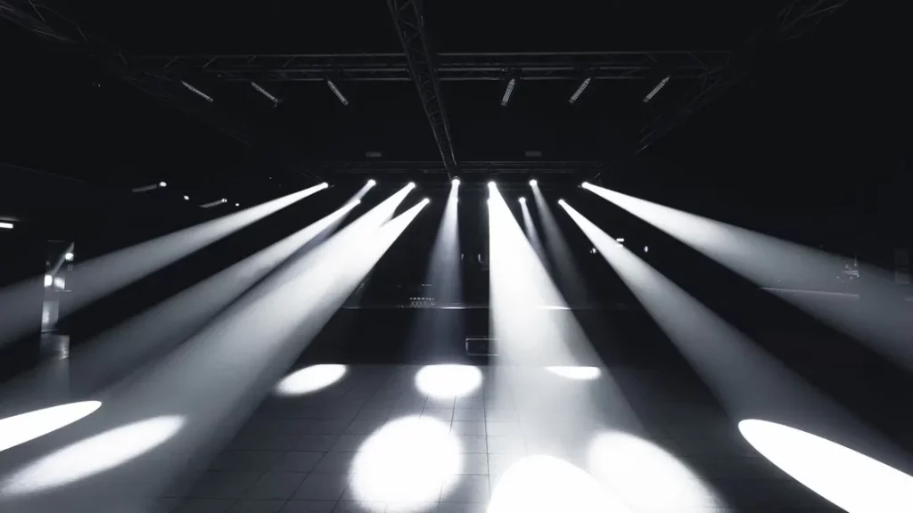 Piste vide au Gate Milano, puissants faisceaux blancs traversant la salle sombre depuis la scène.