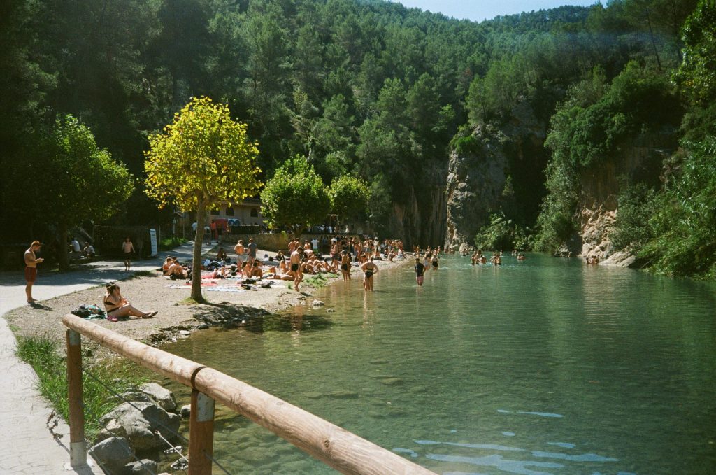 Gente disfrutando del sol al lado de un lago pequeño en festival Dias de Campo 