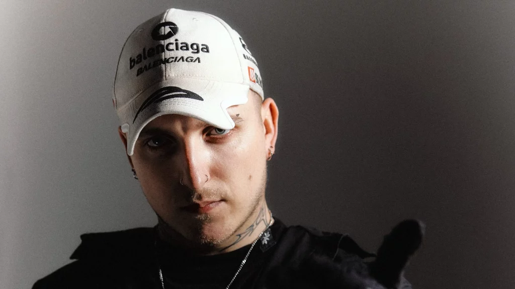 Portrait image of Basswell wearing a Balenciaga cap.