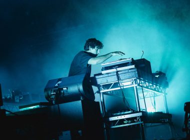 A DJ on stage full of smoke and blue lights