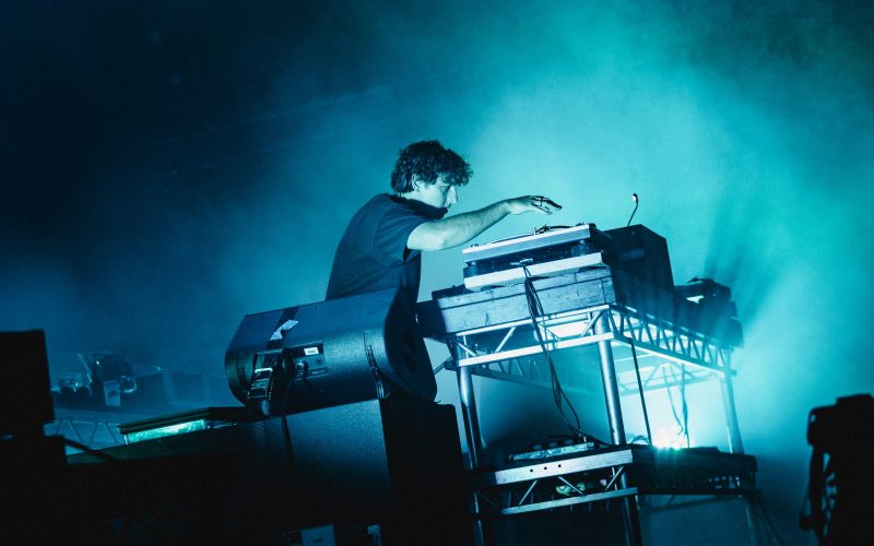 A DJ on stage full of smoke and blue lights