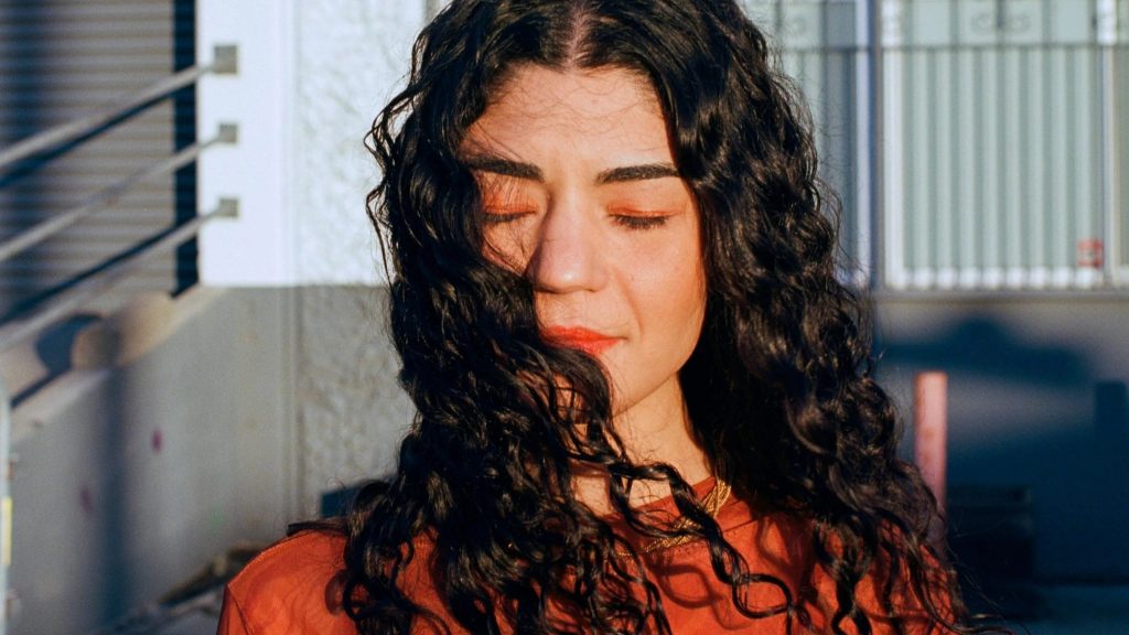 Foto de la DJ AIDA en el exterior con los ojos cerrados