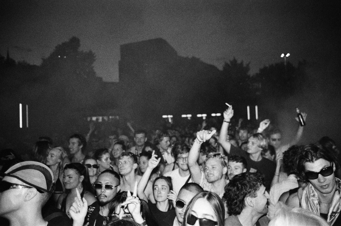 Electronic music open air party crowd on analog film at nighttime